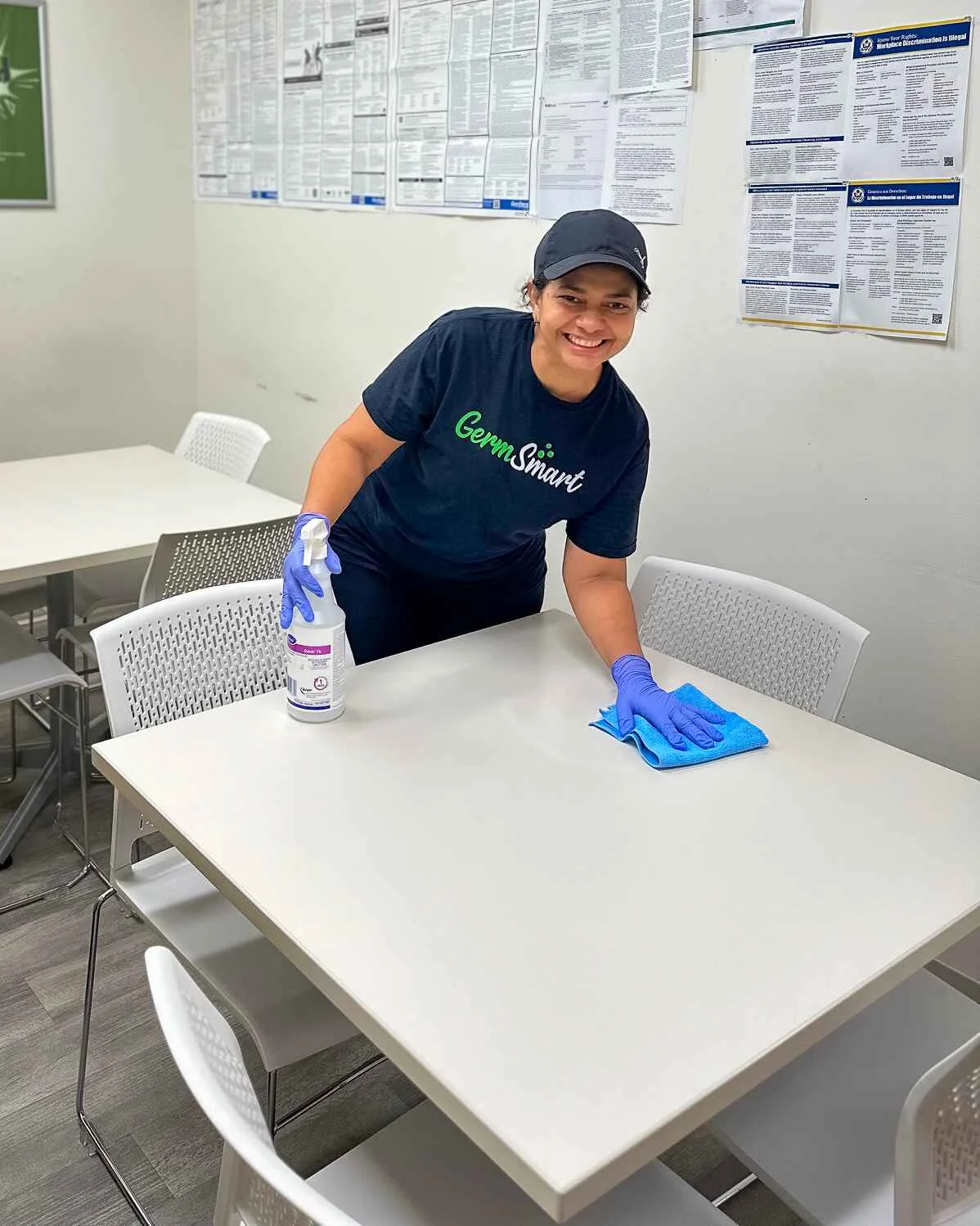 GermSmart cleaner wiping a conference-room table in an office