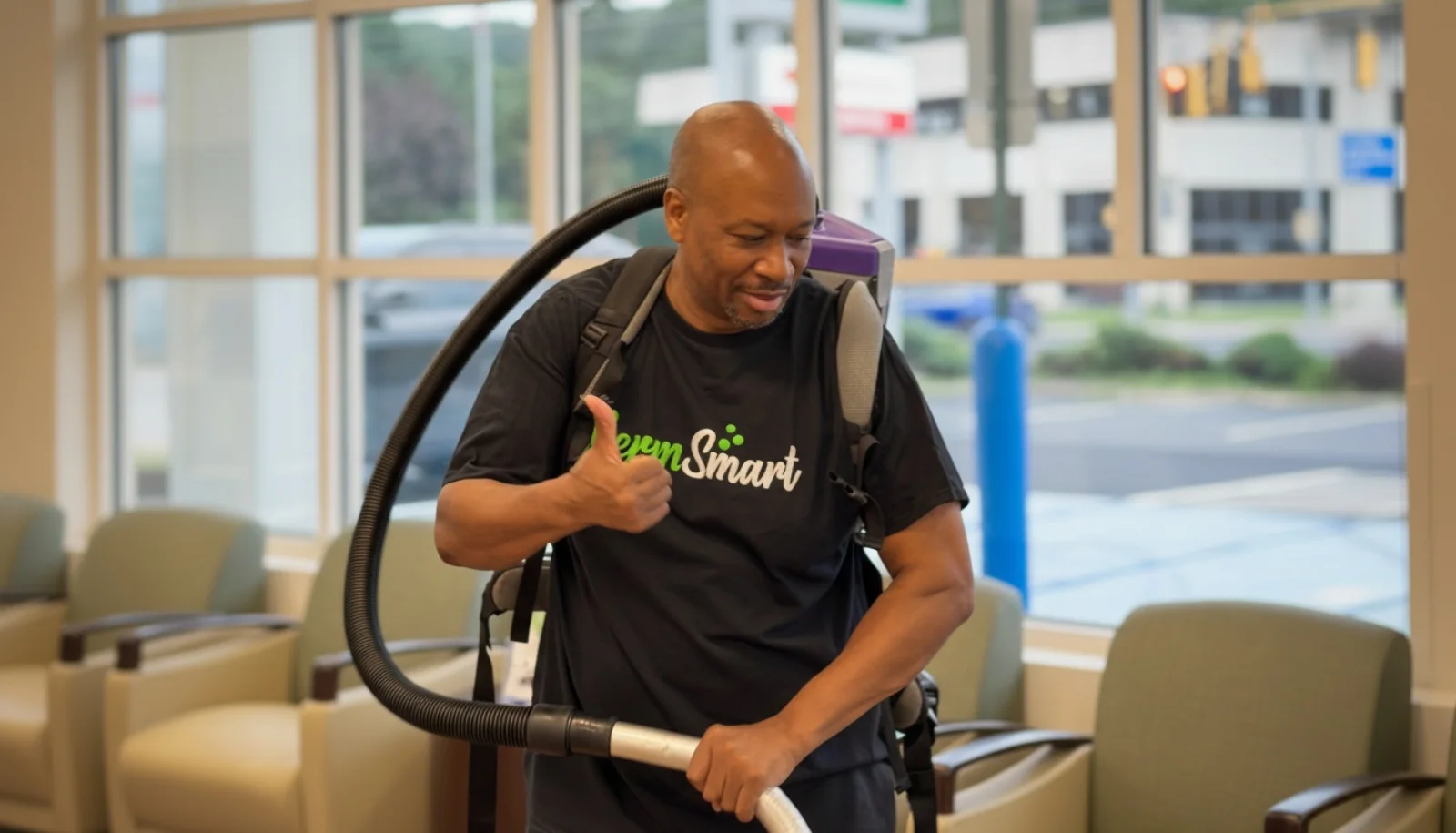 GermSmart cleaner using a backpack vacuum in a customer waiting area